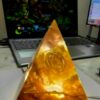 Sacred Light Orgonite Golden Amber Activation Pyramid illuminated with warm amber light