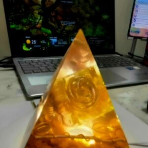 Sacred Light Orgonite Golden Amber Activation Pyramid illuminated with warm amber light