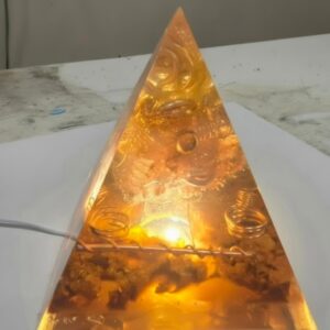 Sacred Light Orgonite Golden Amber Activation Pyramid illuminated with warm amber light
