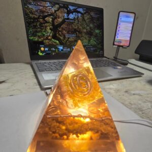 Sacred Light Orgonite Golden Amber Activation Pyramid illuminated with warm amber light