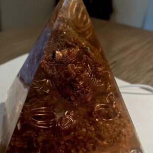 Sacred Light Orgonite Golden Amber Activation Pyramid illuminated with warm amber light