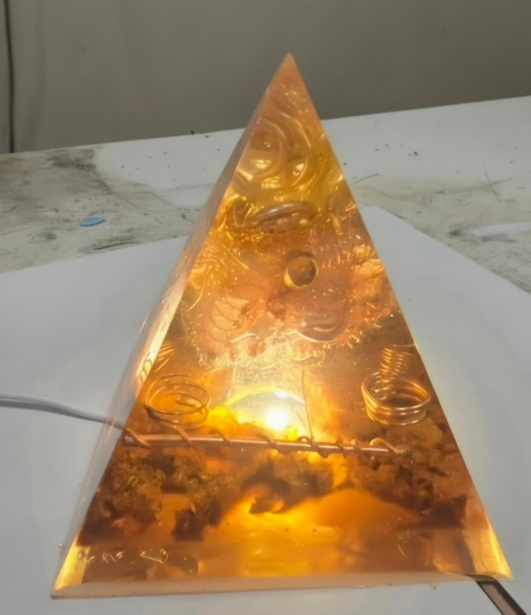 Sacred Light Orgonite Golden Amber Activation Pyramid illuminated with warm amber light